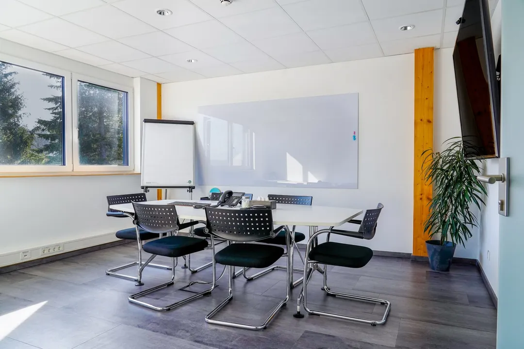 Besprechungsraum von der Fensterseite mit Whiteboard und Flipchart