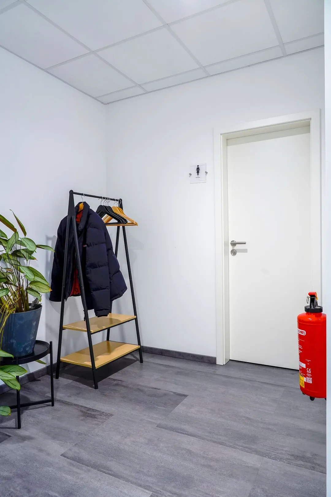 Garderobe mit Kleiderständer, Jacken und Zimmerpflanze